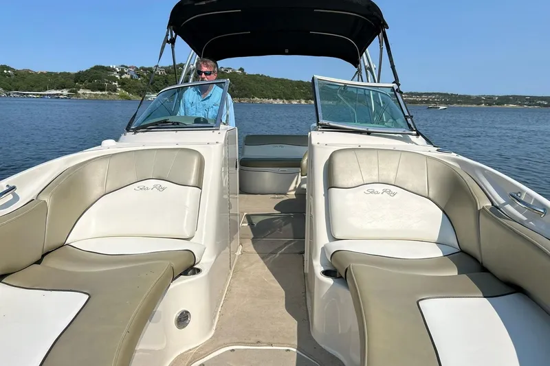 Slide: The Image of 2006 Sea Ray 240 Sundeck boat on water, featuring spacious seating and canopy. - 35