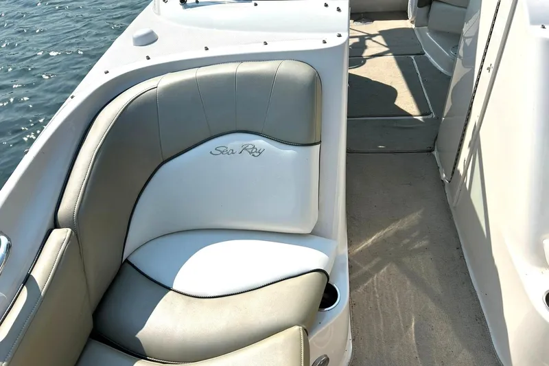 Slide: The Image of 2006 Sea Ray 240 Sundeck interior seating with logo, on calm water. - 37
