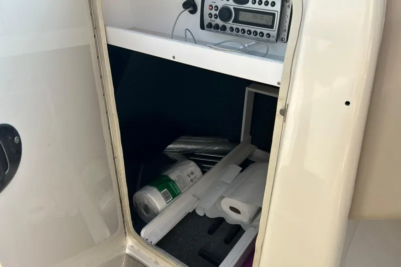 Slide: The Image of Storage compartment in a 2006 Sea Ray 240 Sundeck with radio and supplies. - 38