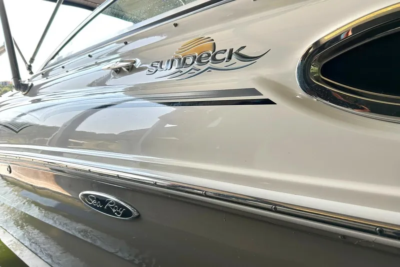 Slide: The Image of 2006 Sea Ray 240 Sundeck boat side view with logo and sleek design. - 39