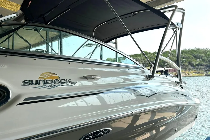 Slide: The Image of 2006 Sea Ray 240 Sundeck boat with canopy, docked by the water. - 40