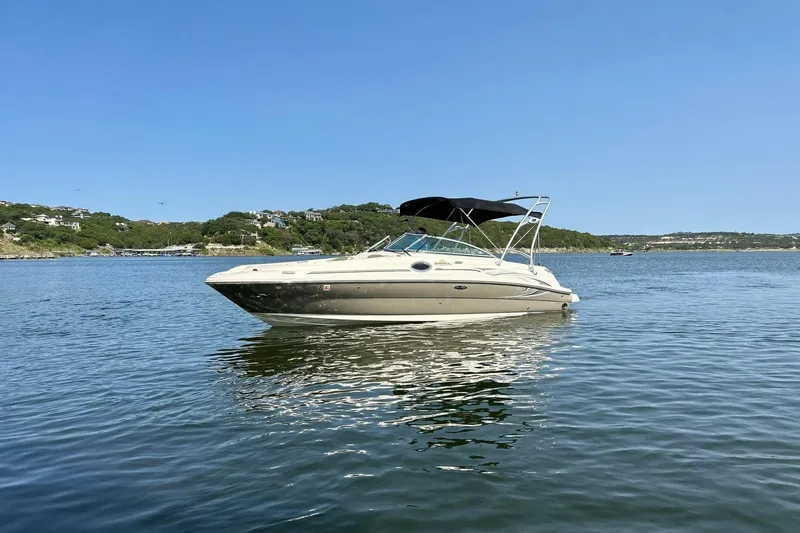 Slide: The Image of 2006 Sea Ray 240 Sundeck boat on calm water under clear blue sky. - 8