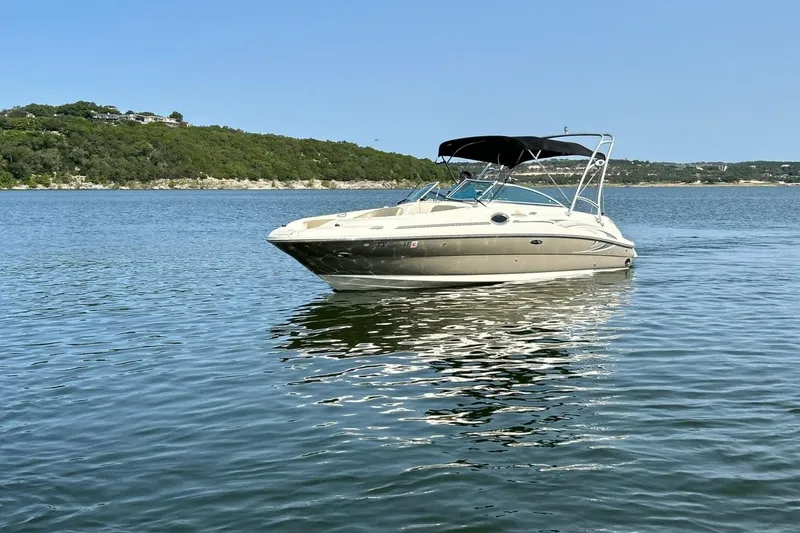 Slide: The Image of 2006 Sea Ray 240 Sundeck boat on calm lake with scenic background. - 9