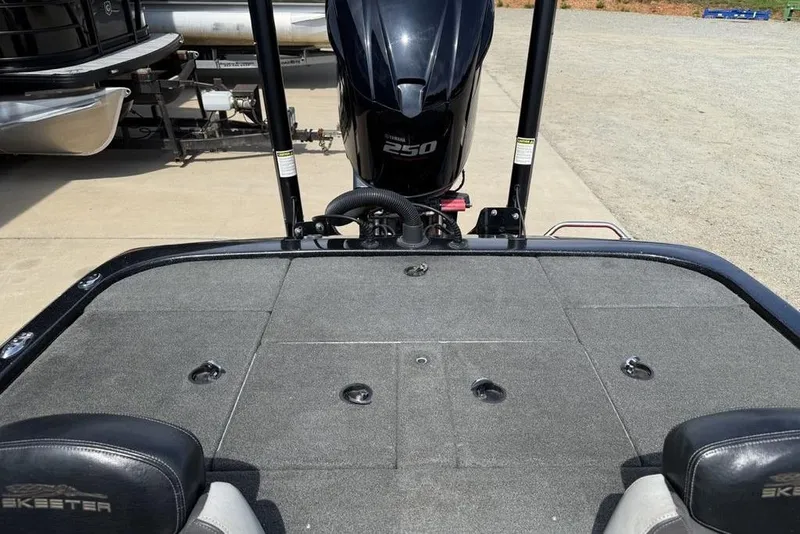 Slide: The Image of 2016 Skeeter ZX250 boat deck with motor, parked on concrete surface. - 20