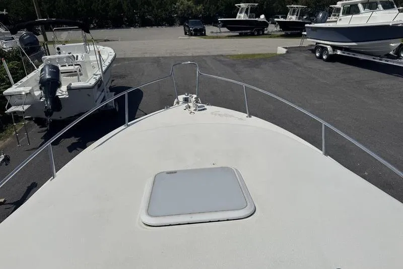 Slide: The Image of Bow view of 2000 Weldcraft 26 Martinque boat in a parking area. - 16