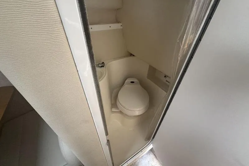 Slide: The Image of Compact bathroom in 2000 Weldcraft 26 Martinque boat, featuring a toilet and sink. - 17