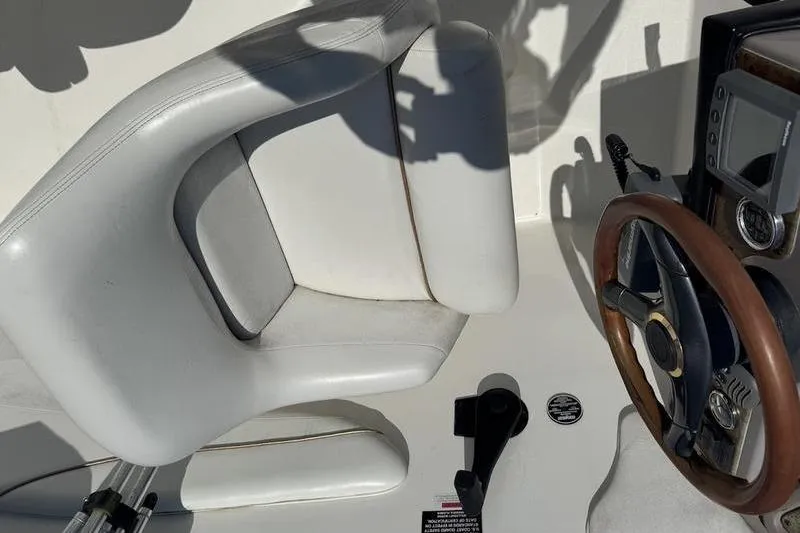 Slide: The Image of Weldcraft 26 Martinque 2000 boat interior with steering wheel and white seat. - 5