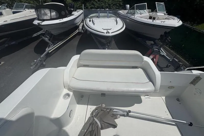 Slide: The Image of 2000 Weldcraft 26 Martinque boat interior with white seating, surrounded by other boats. - 9