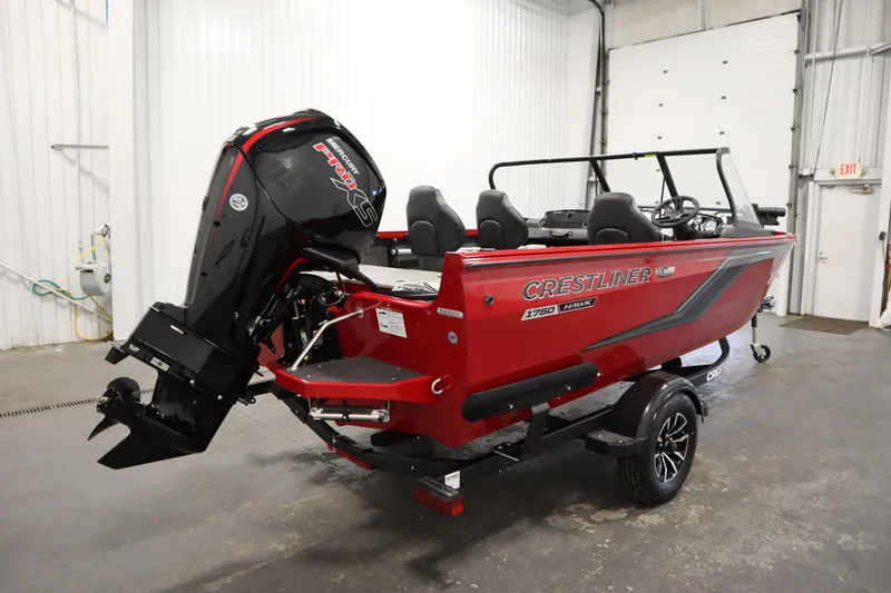 Slide: The Image of 2026 Crestliner 1750 Hawk Walkthrough boat in a garage, featuring a powerful outboard motor. - 4
