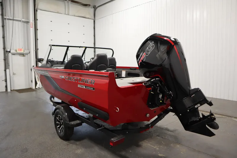 Slide: The Image of 2026 Crestliner 1750 Hawk Walkthrough boat in a garage, featuring a powerful outboard motor. - 6