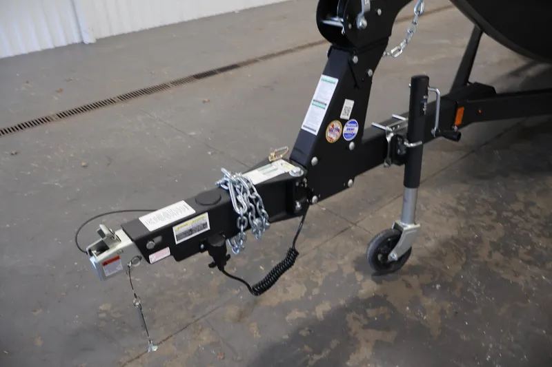 Slide: The Image of Trailer hitch of 2026 Crestliner 1850 Super Hawk boat, featuring safety chains and wheel jack. - 34