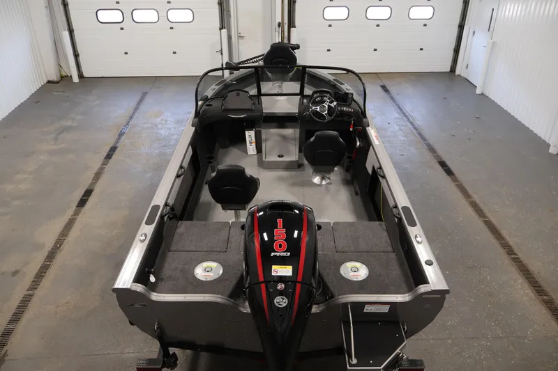 Slide: The Image of 2026 Crestliner 1850 Super Hawk boat interior with seating and controls in a garage setting. - 9