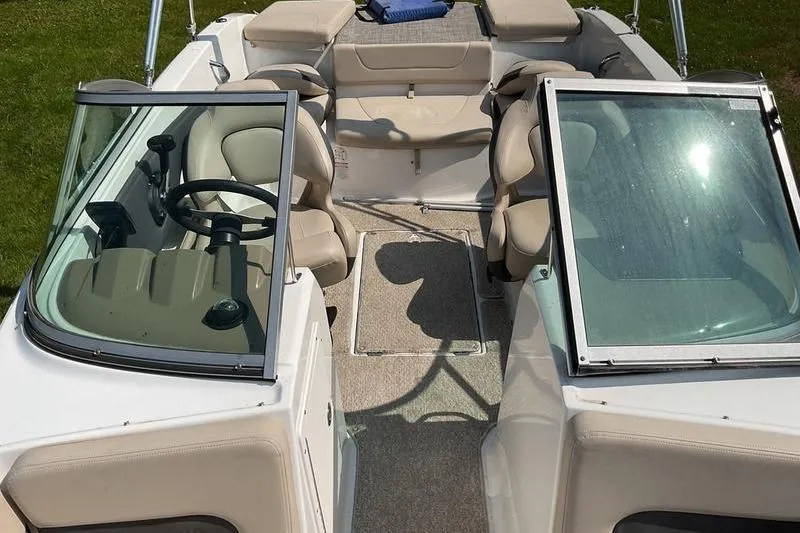 Slide: The Image of 2013 Chaparral H2O Fish & Ski boat interior with beige seating and dual consoles. - 9