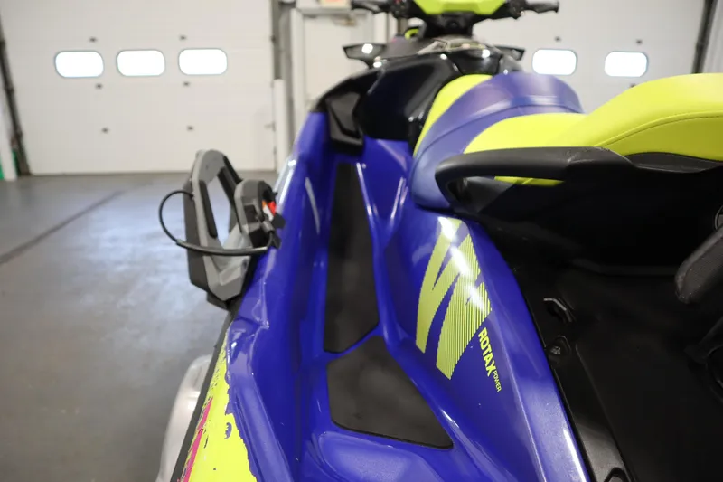 Slide: The Image of 2020 Sea-Doo Wake Pro 230 jet ski in a garage, featuring vibrant blue and yellow design. - 21