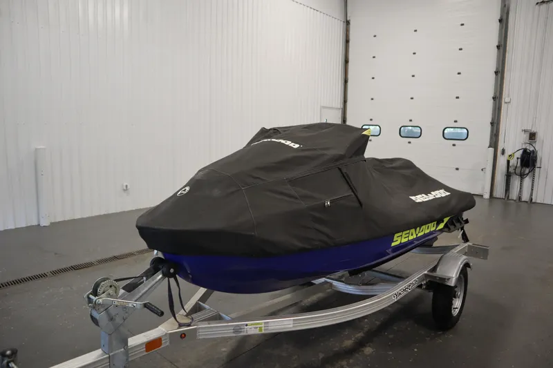 Slide: The Image of 2020 Sea-Doo Wake Pro 230 jet ski covered, on trailer in indoor storage. - 25