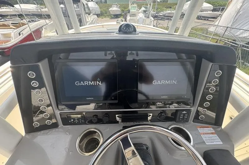 Slide: The Image of 2021 Robalo R242 boat dashboard with dual Garmin displays and steering wheel. - 11