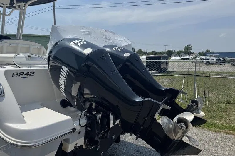 Slide: The Image of 2021 Robalo R242 boat with twin Yamaha outboard engines, parked outdoors. - 2