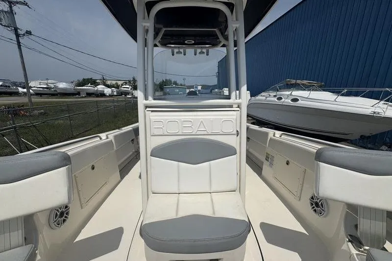 Slide: The Image of 2021 Robalo R242 boat interior with seating and storage, docked near other boats. - 3
