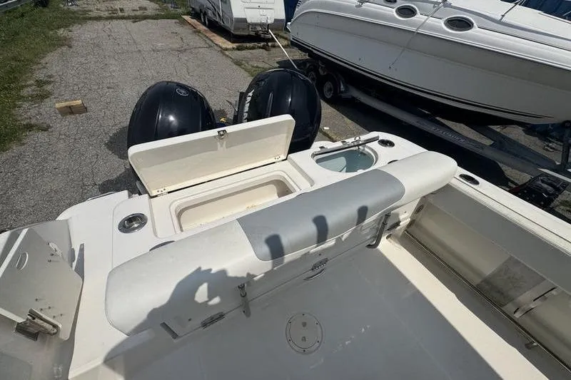 Slide: The Image of 2021 Robalo R242 boat with open storage compartment and dual engines, parked on a lot. - 5