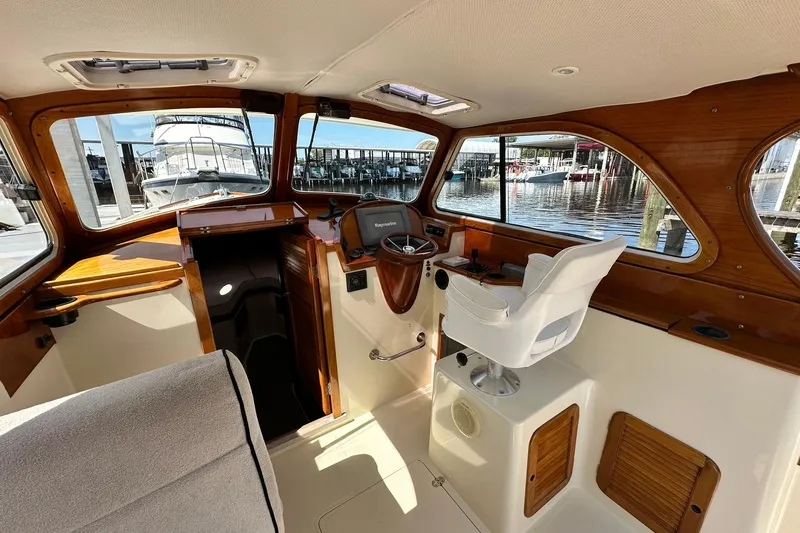 Slide: The Image of Interior of 2000 Hinckley Picnic Boat 36 with helm and marina view. - 13