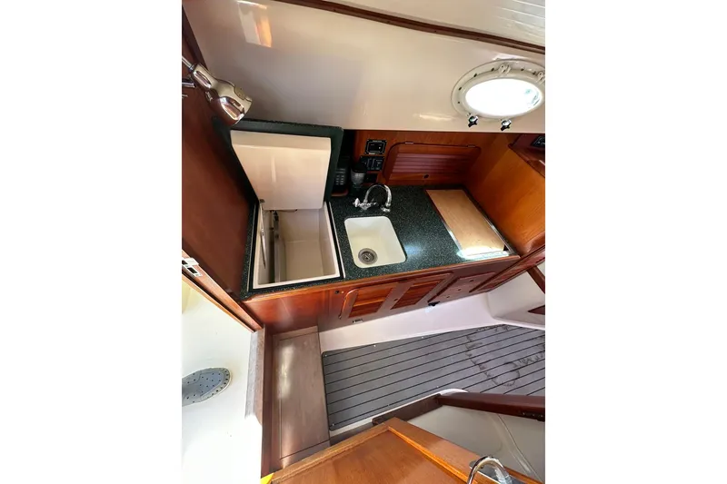 Slide: The Image of Hinckley Picnic Boat 36 (2000) interior galley with sink, countertop, and wooden cabinetry. - 17