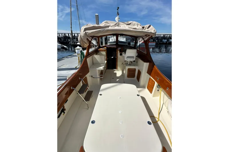 Slide: The Image of 2000 Hinckley Picnic Boat 36 interior view at marina, showcasing seating and helm. - 5