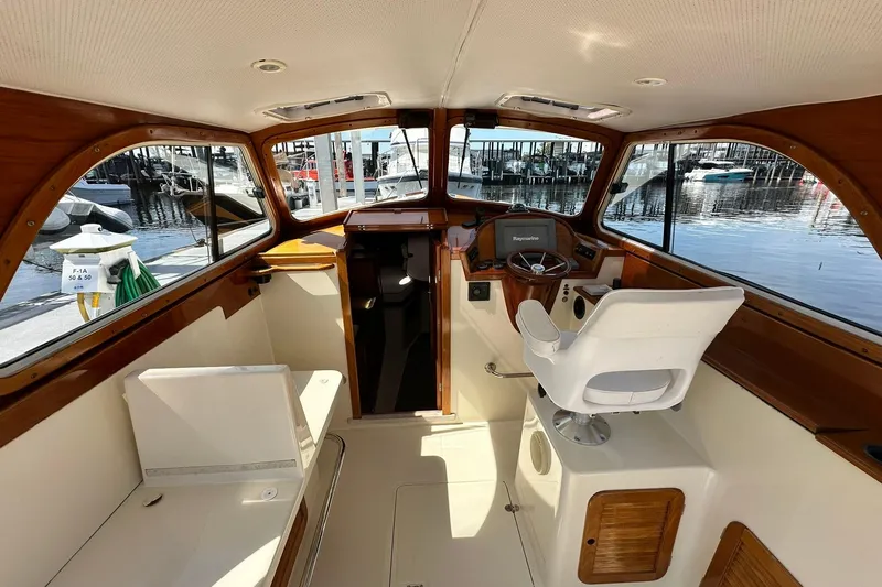 Slide: The Image of Interior of 2000 Hinckley Picnic Boat 36 with helm and seating, docked at marina. - 8