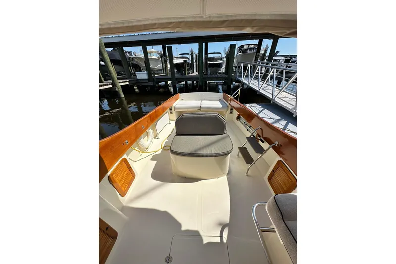 Slide: The Image of Hinckley Picnic Boat 36, 2000 model, featuring spacious deck and elegant wood accents at dock. - 10