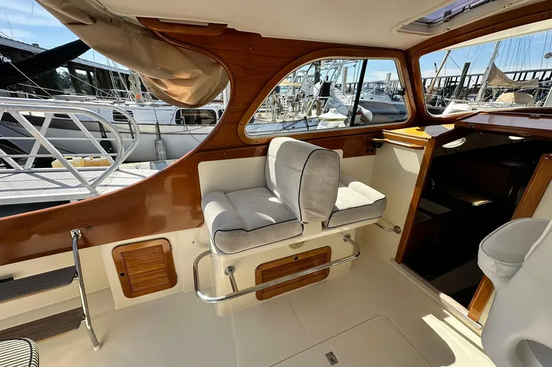 Slide: The Image of Interior of 2000 Hinckley Picnic Boat 36 with cushioned seating and wooden accents. - 12