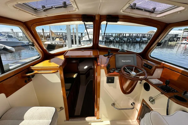 Slide: The Image of Interior of 2000 Hinckley Picnic Boat 36 with wooden dashboard and marina view. - 15
