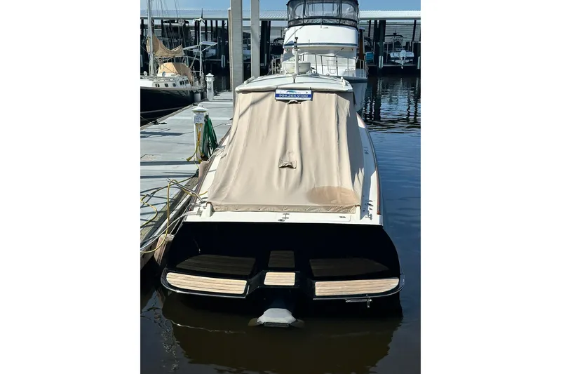 Slide: The Image of 2000 Hinckley Picnic Boat 36 docked with cover, rear view. - 2