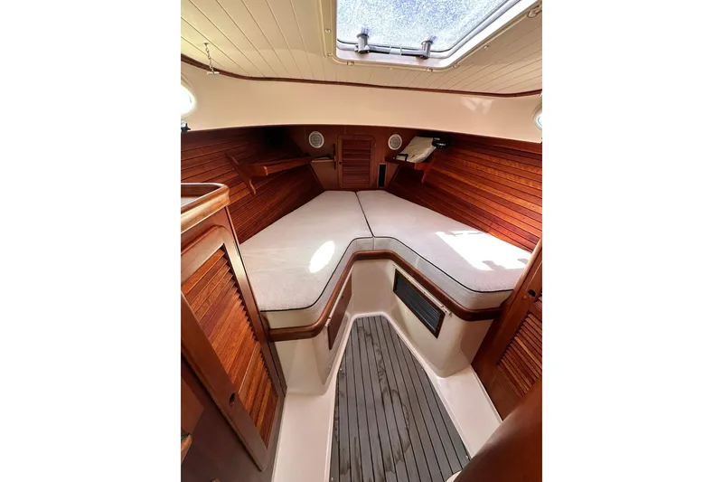 Slide: The Image of Interior of 2000 Hinckley Picnic Boat 36, featuring cozy wooden cabin and cushioned seating. - 23