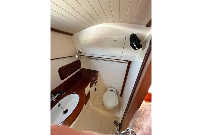 Slide: The Image of Hinckley Picnic Boat 36 (2000) bathroom with sink, toilet, and wooden cabinetry. - 26