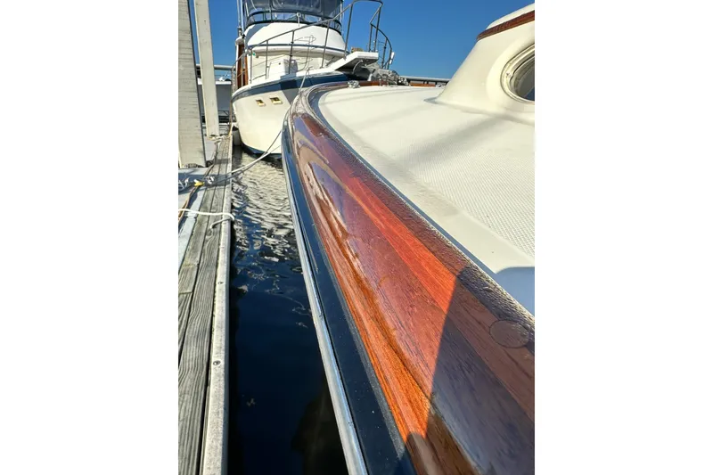 Slide: The Image of Hinckley Picnic Boat 36, 2000 model, docked with polished wood detailing and sleek design. - 6