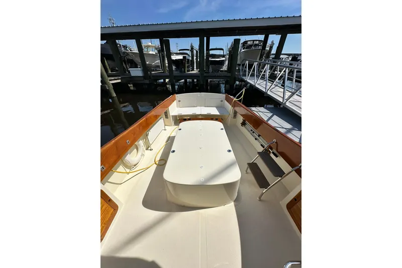 Slide: The Image of 2000 Hinckley Picnic Boat 36 docked, showcasing spacious deck and elegant wood finishes. - 9