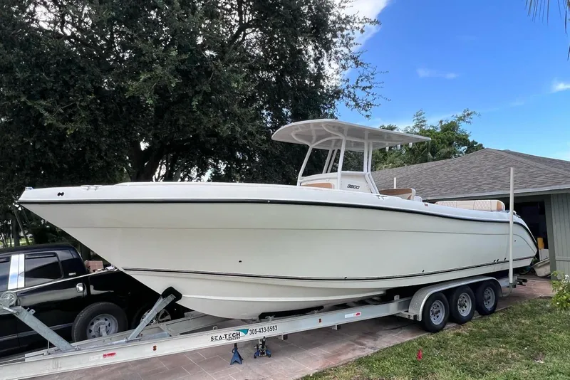 Slide: The Image of 2019 Century 3200 Center Console boat on trailer, parked near a house. - 11