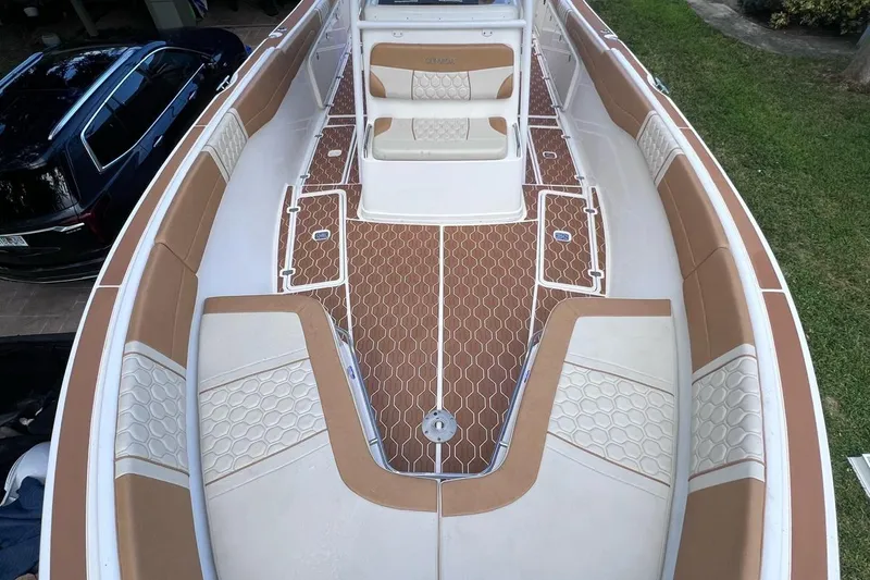 Slide: The Image of 2019 Century 3200 Center Console boat with tan and white seating, brown deck, and spacious layout. - 2