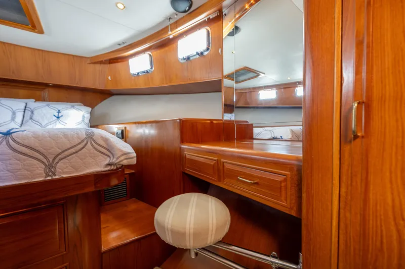 Slide: The Image of Luxurious 1995 Ocean Alexander VIP cabin with wooden interior and cozy bedding and office or make up pulls out stool. - 39