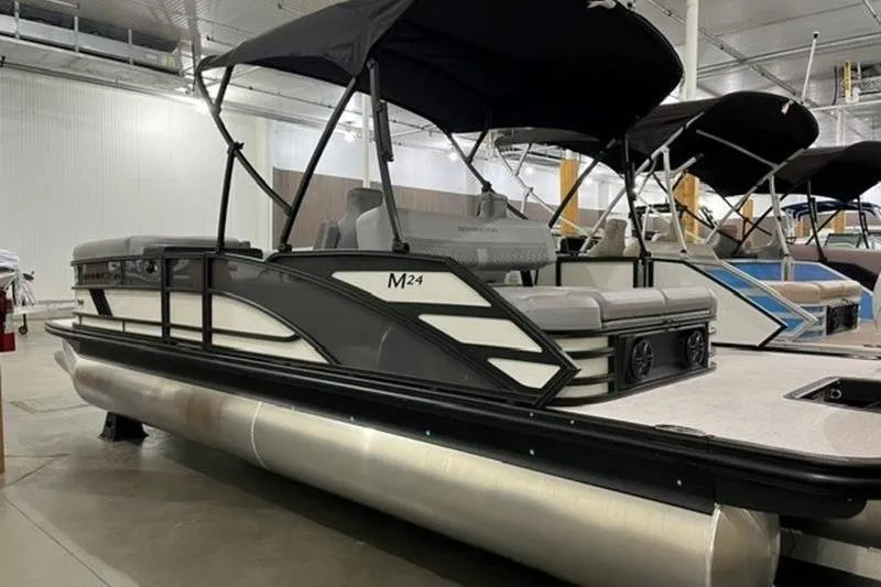 Slide: The Image of 2025 Bennington 24MSB pontoon boat with canopy in showroom setting. - 1