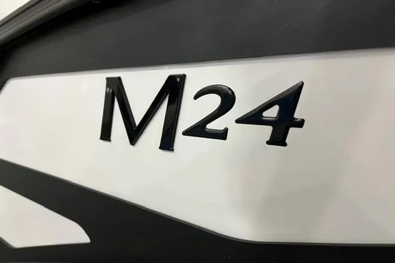Slide: The Image of Close-up of 2025 Bennington 24MSB boat model emblem, M24, on sleek black and white surface. - 4
