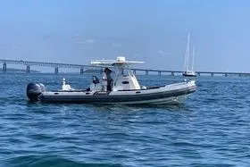 Slide: The Image of 2015 Zodiac 28 Pro Optimum boat on water near a bridge, clear sky. - 11