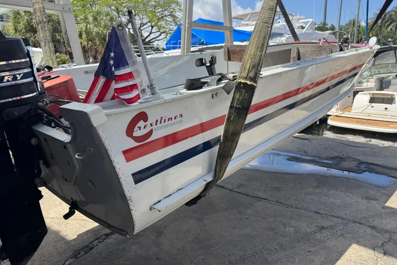 Slide: The Image of 1960 Crestliner Wildwood 19 boat with American flag, docked and lifted by straps. - 13