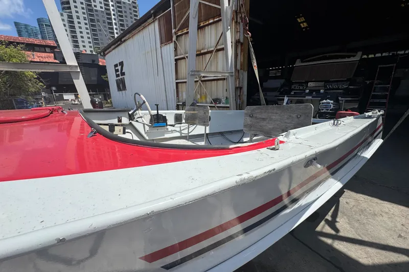 Slide: The Image of 1960 Crestliner Wildwood 19 boat with red and white design in urban setting. - 18