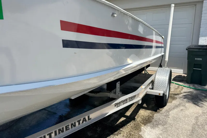 Slide: The Image of 1960 Crestliner Wildwood 19 boat on trailer, featuring red and blue stripes. - 2