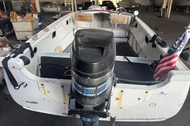 Slide: The Image of 1960 Crestliner Wildwood 19 boat with outboard motor and flag in a storage facility. - 22