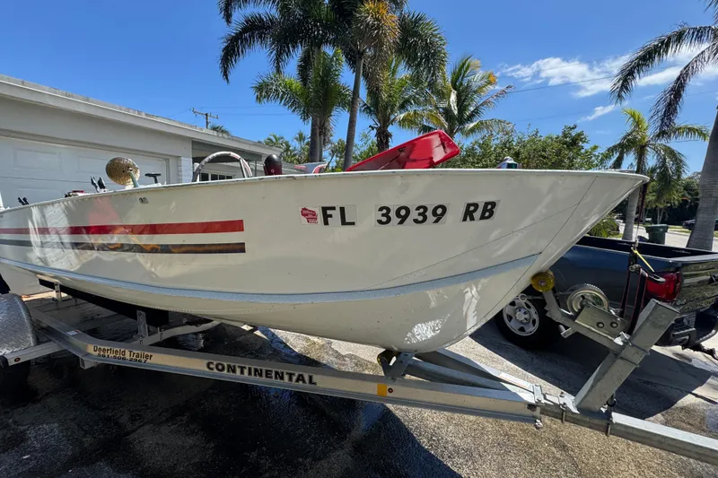 Slide: The Image of 1960 Crestliner Wildwood 19 boat on trailer, parked near palm trees and a garage. - 3