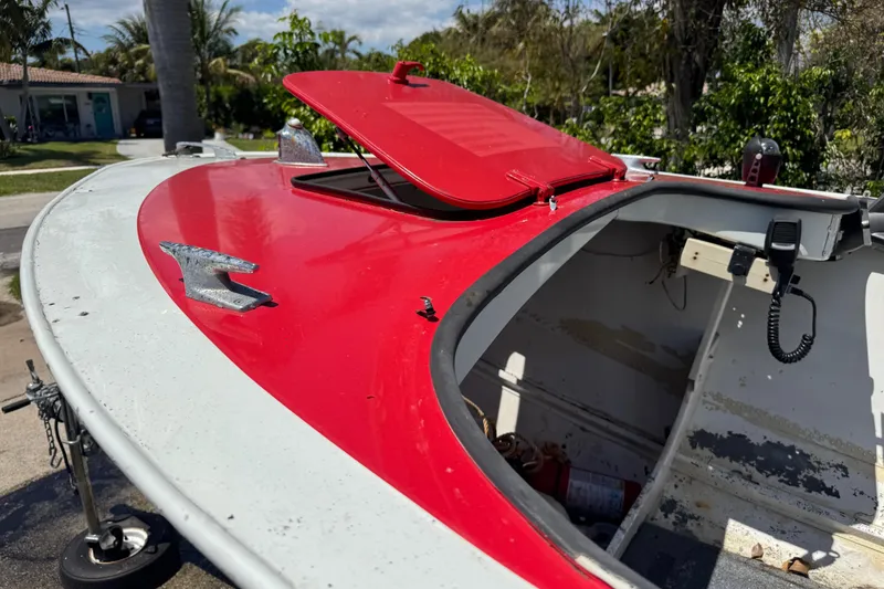 Slide: The Image of 1960 Crestliner Wildwood 19 boat with red and white exterior, open hatch, and visible interior. - 6