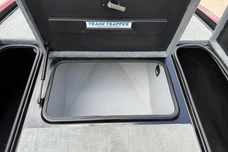 Slide: The Image of Open storage compartment in a 2005 Triton TR 19 X boat labeled "Trash Trapper." - 10