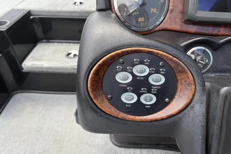 Slide: The Image of Control panel of a 2005 Triton TR 19 X boat with various switches and gauges. - 16