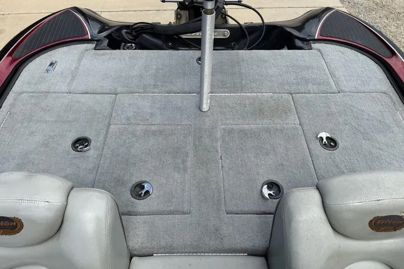 Slide: The Image of 2005 Triton TR 19 X boat interior with gray carpet and storage compartments. - 22
